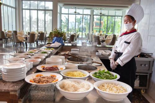 a chef standing in front of a buffet of food at Castle Bayview Resort & Spa in Kampot