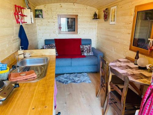 a kitchen with a sink and a couch in a room at La Rouloulotte in Durbuy