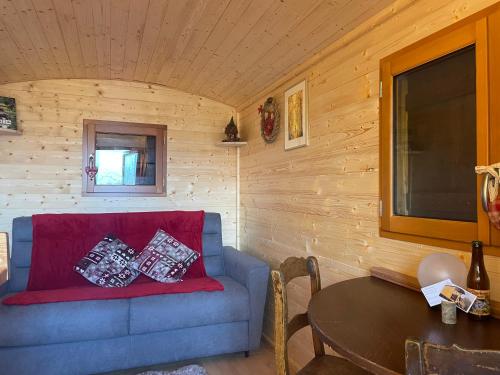 a living room with a blue couch and a table at La Rouloulotte in Durbuy