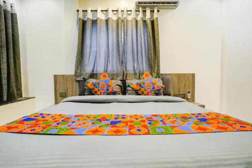 a bed with a colorful blanket on top of it at FabHotel Viva House - Talegaon in Pune