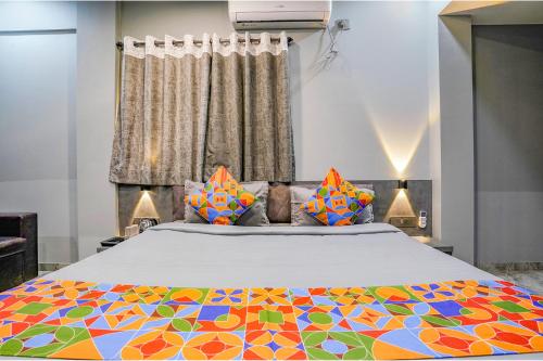 a bedroom with a large bed with a colorful blanket at FabHotel Viva House in Pune