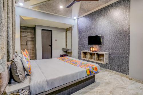 a bedroom with a bed and a tv on a wall at FabHotel Viva House - Talegaon in Pune