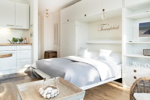 um quarto branco com uma cama e uma mesa em Haus Baltic Wohnung 20 em Scharbeutz