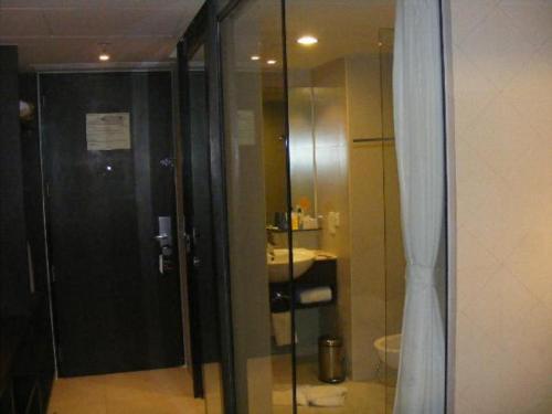 a bathroom with a glass shower with a sink at Keys Select by Lemon Tree Hotels, Hosur Road, Bengaluru in Bangalore