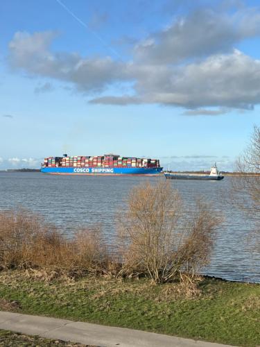 a large blue container ship on the water at Peedy's luxuriöse 60m² Wohnung mit Balkonterrasse in Stade