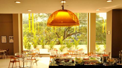 un restaurante con mesas y sillas y una gran ventana en Keys Select by Lemon Tree Hotels, Kochi, en Kochi