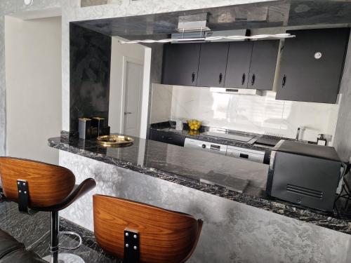 una cucina con bancone, due sedie e lavandino di Onyx apartment a Puerto del Carmen