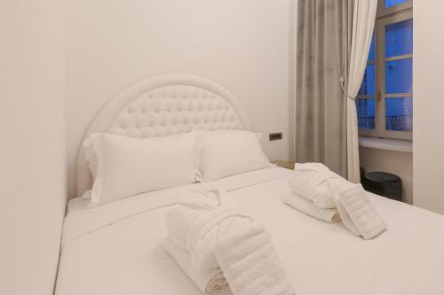 a white bed with white sheets and pillows at Residenza di Fedralia in Nafplio