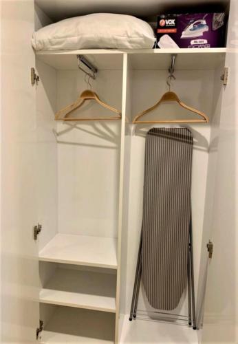 a white closet with two hangers and a radiator at Next Wave Aparthotel in Batumi