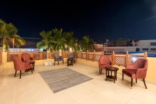 a patio with chairs and tables on a balcony at night at Hotel The Rivaaj in Rohtak