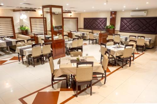 uma sala de jantar com mesas e cadeiras em Hotel The Rivaaj em Rohtak