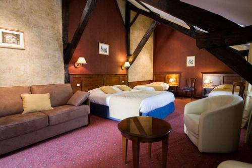 a hotel room with two beds and a couch at Coq hôtel in Montreuil-sur-Mer