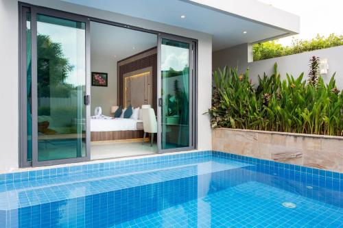 a villa with a swimming pool and a bedroom at Castle Bayview Resort & Spa in Kampot
