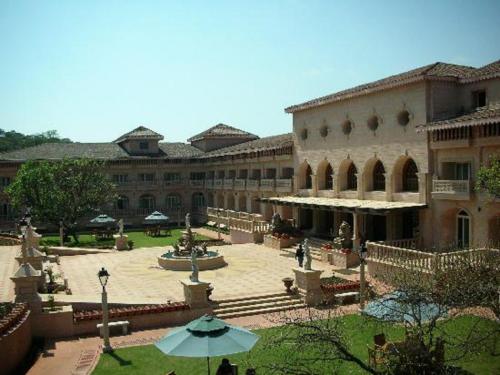 a large building with a courtyard with a fountain at Evershine Resort & Spa in Mahabaleshwar