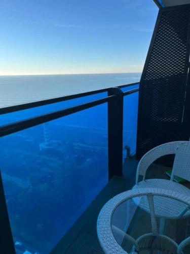 a chair on a balcony with a view of the ocean at Next Wave Aparthotel in Batumi