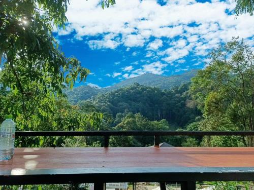 una mesa de picnic con vistas a las montañas en บ้านชายดอย Glamping ดอยแม่แจ๋ม cheason ,Muangpan, Lampang en Ban Mai
