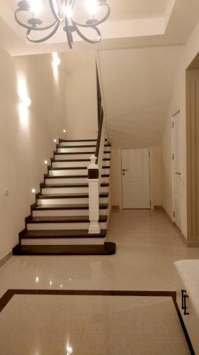 a staircase in a house with a chandelier at Villa Gilavar in Baku