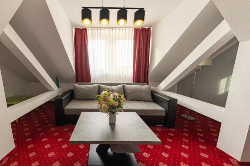 a living room with a couch and a table at Hotel Berlin in Leipzig