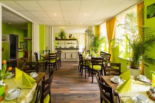 a restaurant with green walls and wooden tables and chairs at Hotel Berlin in Leipzig