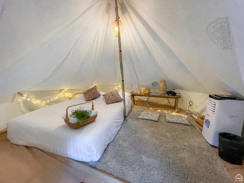 a bedroom with a white bed in a tent at เดอะริเวอร์ แม่กำปอง The River Maekampong Chiang Mai in Ban Pok Nai
