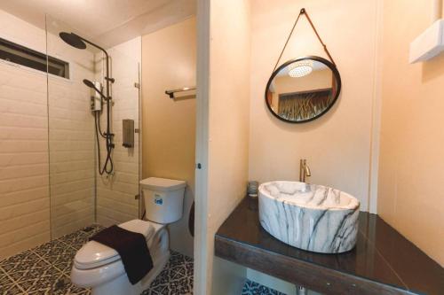 a bathroom with a sink and a toilet and a mirror at เดอะริเวอร์ แม่กำปอง The River Maekampong Chiang Mai in Ban Pok Nai