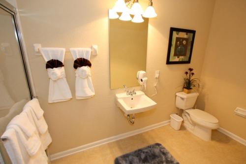 W łazience znajduje się umywalka, toaleta i lustro. w obiekcie IT319 - Vista Cay Resort - 3 Bed 3,5 Baths Townhome w Orlando