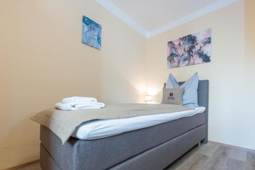 a small bedroom with a bed with white sheets at Gasthaus Hinterbrühl in Salzburg