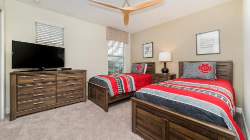 1 dormitorio con 2 camas y TV de pantalla plana en Storey Lake Resort - 5 Bed 5 Baths VILLA, en Kissimmee