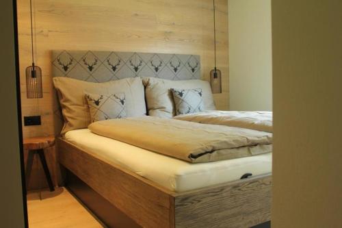 um quarto com uma cama e uma cabeceira em madeira em Chesa Freihof em Celerina