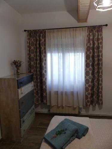 a bedroom with a bed and a dresser and a window at Casa Carrasquillas in Cañada del Hoyo
