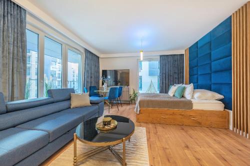 salon z kanapą i łóżkiem w obiekcie Glow Apartments, Letnica - Apartamenty Przystań Siódme Niebo w Gdańsku