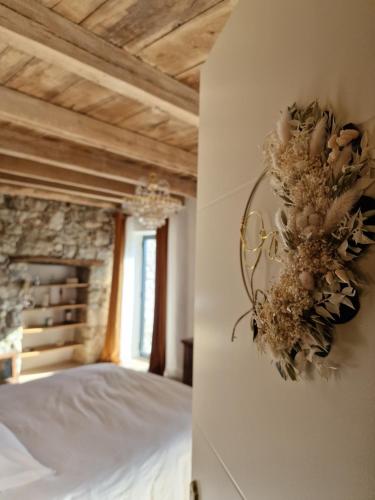 a bedroom with a bed and a flower wreath on a wall at Casa Nanuccia in Bastelica