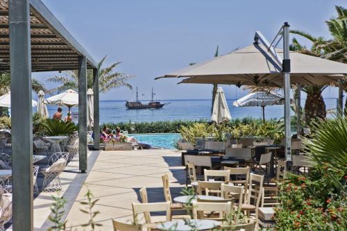 
a patio area with chairs, tables and umbrellas at Aegean Pearl in Rethymno Town

