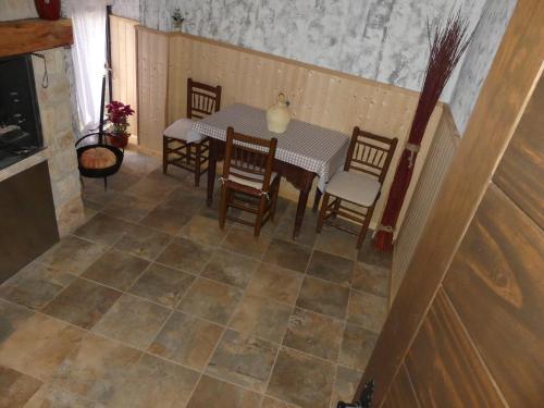 a dining room with a table and chairs on a tiled floor at Casa Carrasquillas in Cañada del Hoyo