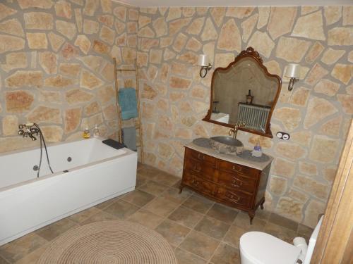 a bathroom with a tub and a sink and a mirror at Casa Carrasquillas in Cañada del Hoyo