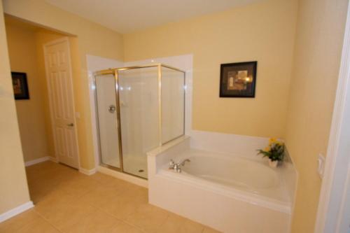 a bathroom with a shower and a tub with a sink at IT212 - Vista Cay Resort - 2 Bed 2 Baths Condo in Orlando