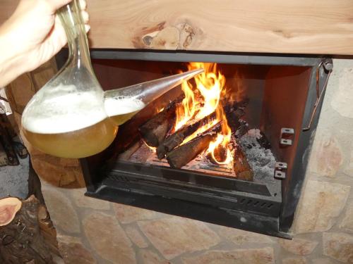a person cooking food over a fire in a stove at Casa Carrasquillas in Cañada del Hoyo