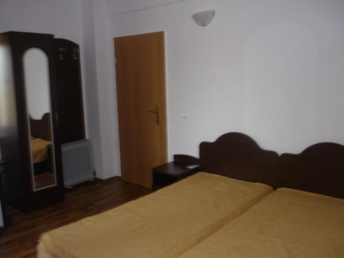 1 dormitorio con 1 cama grande y espejo en Pensiunea Cristiana - Murighiol, en Murighiol