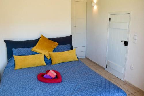 a red hat sitting on a blue bed with yellow pillows at Stylish Manihaus for a romantic adventure in Stoupa