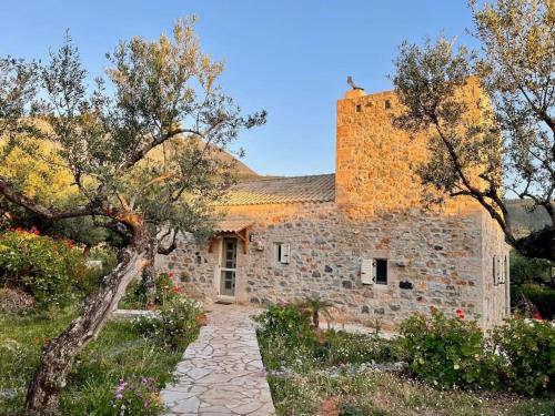a stone house with a stone pathway in front of it at Stylish Manihaus for a romantic adventure in Stoupa