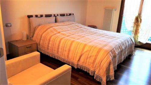 ein Schlafzimmer mit einem Bett mit einer orangen und weißen Decke in der Unterkunft Residence Lucia 2 in Grado