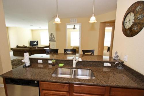 a kitchen with a sink and a clock on the wall at IT289 - Vista Cay Resort - 3 Bed 2 Baths Condo in Orlando
