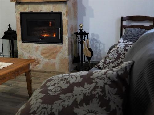 a living room with a fireplace and a bed and a couch at Casa Carrasquillas in Cañada del Hoyo