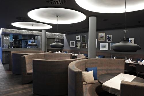a restaurant with tables and chairs and pendant lights at Badhaus - Hotel/Restaurant/Café in Bad Hall