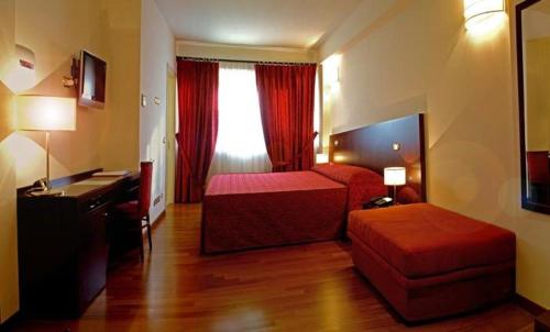 a hotel room with a bedroom with a bed and a desk at Hotel Ristorante Il Gambero in Porto SantʼElpidio