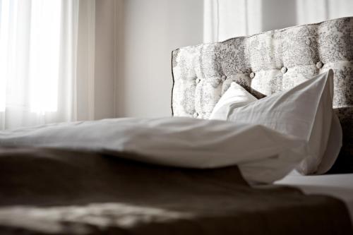 a bed with a white pillow and a window at Badhaus - Hotel/Restaurant/Café in Bad Hall
