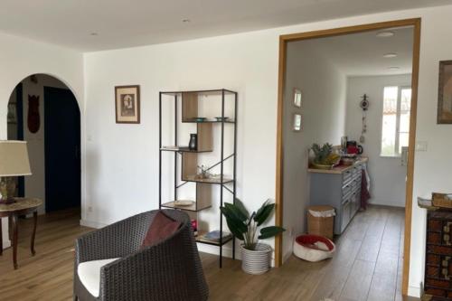 a living room with a chair and a mirror at Charming apartment overlooking the lake city in Grimaud