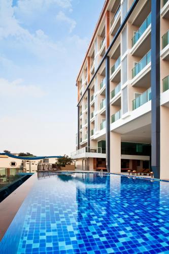 a swimming pool in front of a building at Balihai Bay Pattaya in Pattaya South