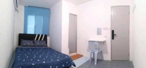 a bedroom with a blue bed and a desk at SPOT ON 90735 night Stayin in Sibu
