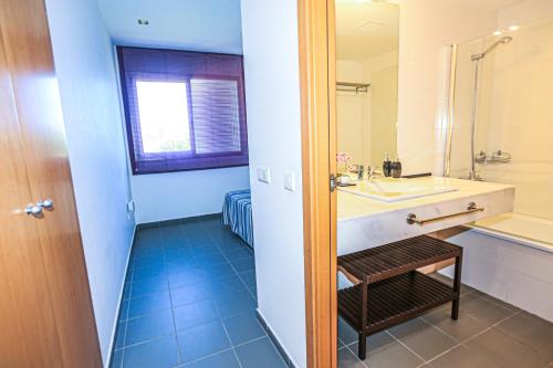 un baño con lavabo y espejo en LITORAL COSTA DORADA - LAS PALMERAS Only families, en Mont-roig